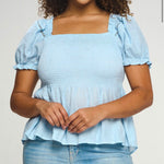 Blue puff sleeve top with a square neckline, a shirred bodice, and a peplum style. This has a very nice stretch to it & is sheer material where it flares out under the bust.